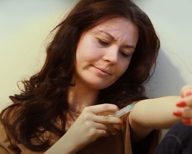 Женщина делает инъекцию себе в руку